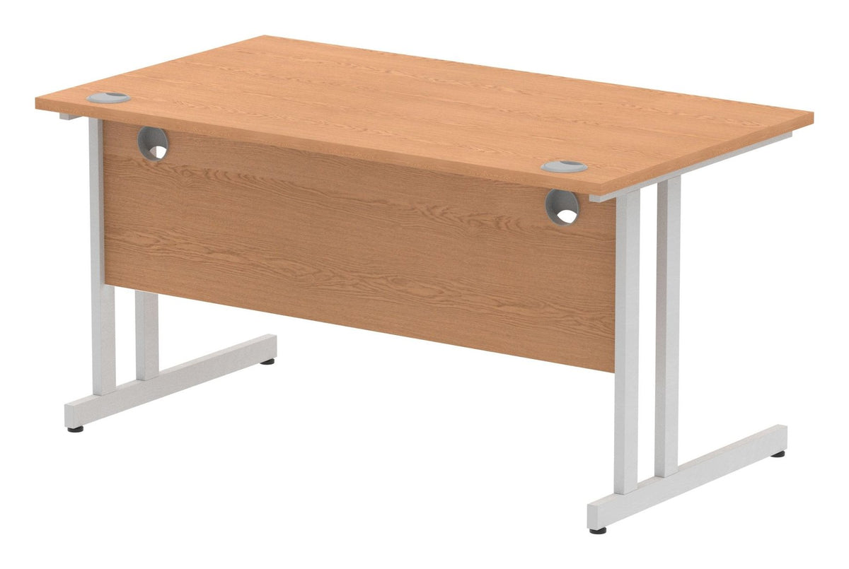 Impulse Pastel straight desk with cantilever legs, shown in oak with a silver frame, view from the back at an angle